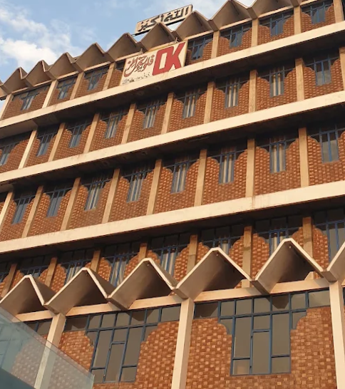 OK Flour Mill building — brick facade with OK signage against a clear blue sky