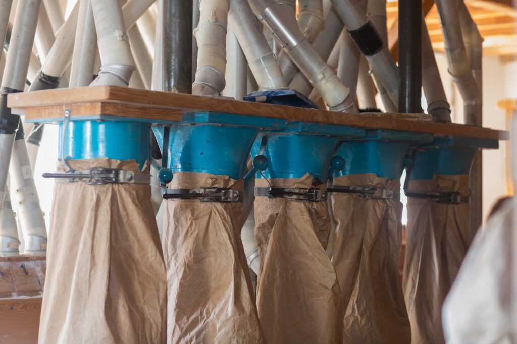 Milling machine with pipes and flour sacks at wheat mill