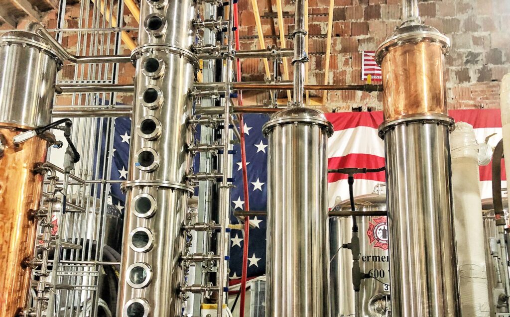 Moonshine Gin Mill Machinery with American Flag in Background